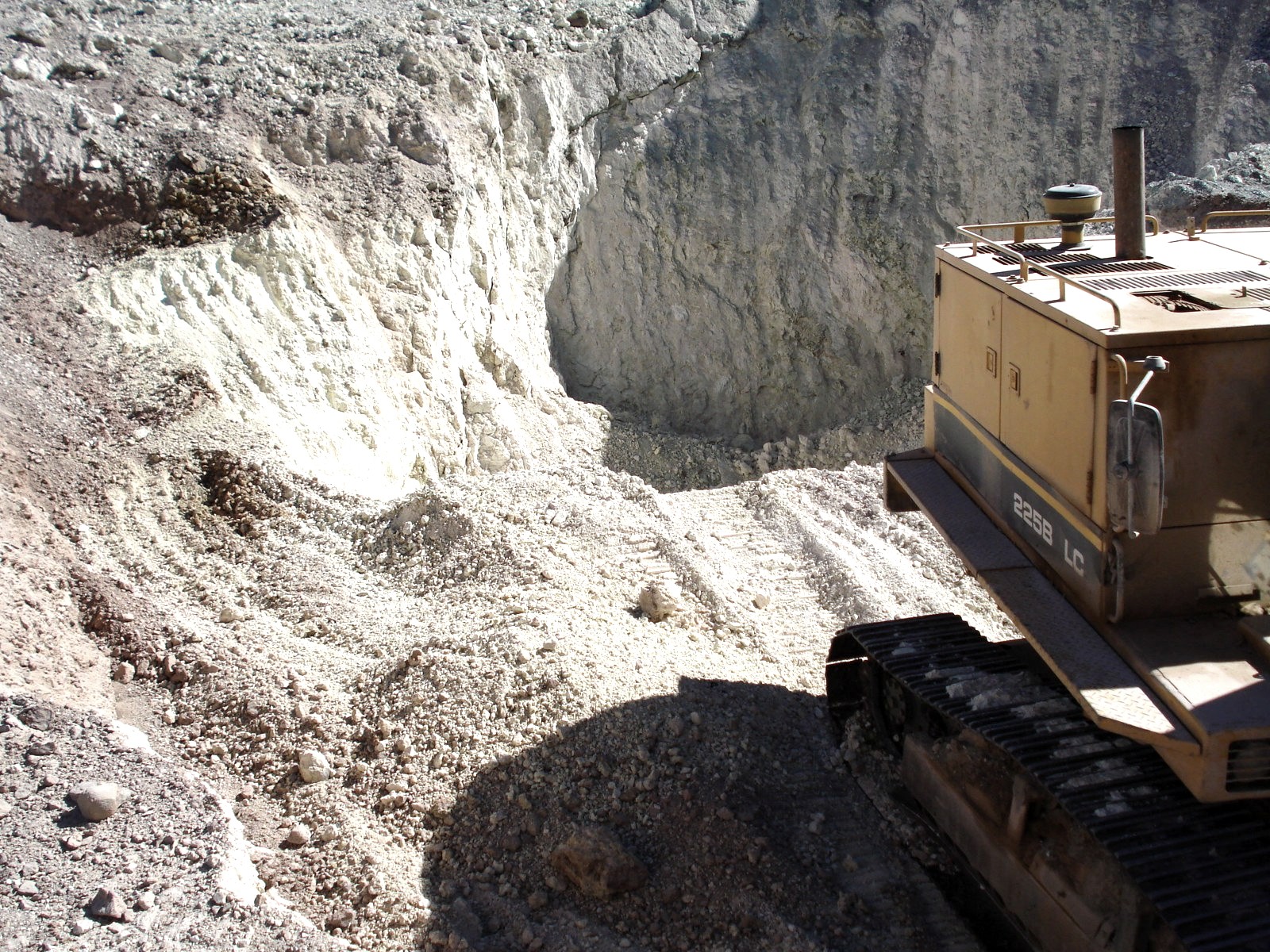 Excavadora trabajando en cantera de mineral blanco